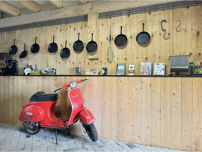Houten muur met een rode Vespa er voor